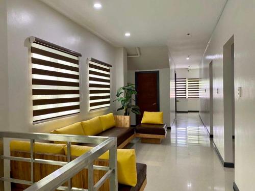 - un salon avec un canapé jaune et des oreillers jaunes dans l'établissement Kara’s Pension House, à Tuguegarao