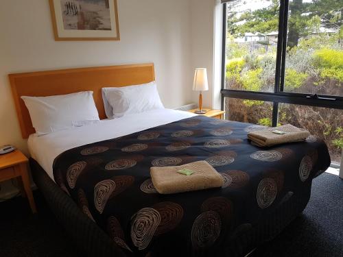 a bedroom with a bed with two towels on it at Gilles St Apartments in Warrnambool