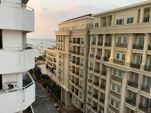 an apartment building with the ocean in the background at A.A. Pattaya Golden Beach Hotel in Pattaya Central