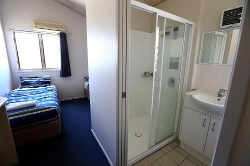 La petite salle de bains est pourvue d'une douche et d'un lavabo. dans l'établissement Gold Coast Performance Centre, à Gold Coast