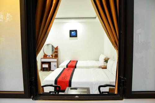 a bedroom with a bed and a mirror at Asean Garden Homestay Hue in Hue