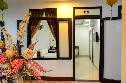 a room with a mirror and a room with a bed at Asean Garden Homestay Hue in Hue