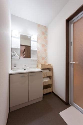 a bathroom with a sink and a mirror at Tsukuyomi Higashiyama in Kanazawa