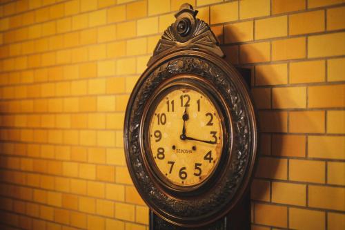 a clock is hanging on a wall at Hotel Kajiwara in Matsuyama