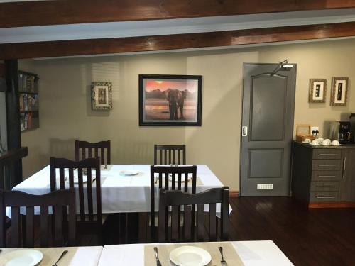 St Lucia的住宿－Turaco Guest House，用餐室配有桌椅和墙上的照片