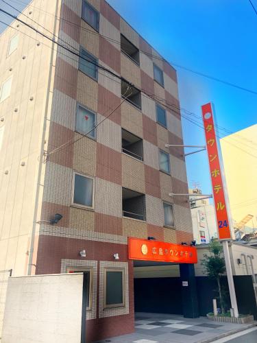 a building with a red sign in front of it at Hiroshima Town Hotel in Hiroshima