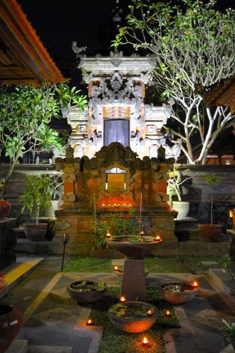 a garden with a fountain in front of a building at Kandjeng Puri Kailas Canggu in Sempidi