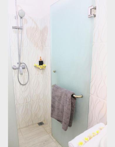 a bathroom with a shower with a gray towel at Kandjeng Puri Kailas Canggu in Sempidi