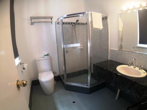a bathroom with a shower and a toilet and a sink at Criterion Hotel Perth in Perth