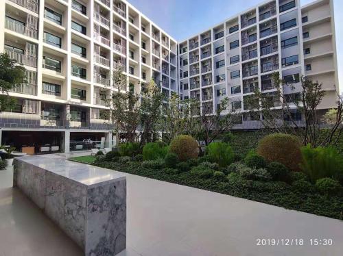 a large apartment building with a bench in front of it at D2 residences huahin 华欣市中心近海滩近商场酒店式公寓可加床有连通房型 in Hua Hin