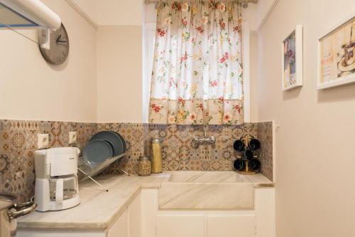 eine Küche mit einem Waschbecken und einem Fenster in der Unterkunft Syntagma 3 Bedroom Sweet And Practical Apartment in Athen