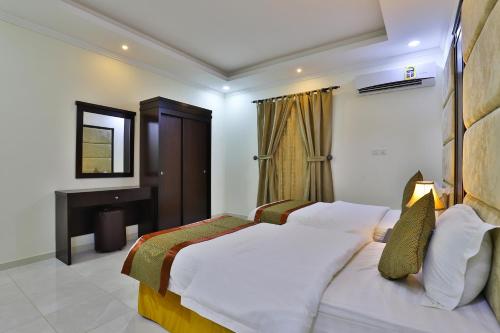une chambre d'hôtel avec un lit et une télévision dans l'établissement Moon Gate 2, à Yanbu
