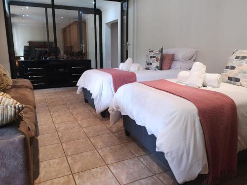 a bedroom with two beds and a couch at Riverdance in Komnader