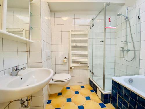 ein Bad mit einem Waschbecken, einem WC und einer Dusche in der Unterkunft Gartenhaus Villa Sanssouci in Heringsdorf