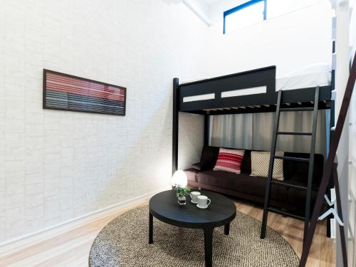 a living room with a bunk bed and a table at TRIP POD TAKASAGO B in Fukuoka