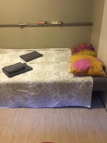 a bed with two pillows and a blanket on it at Apartamenti in Cēsis