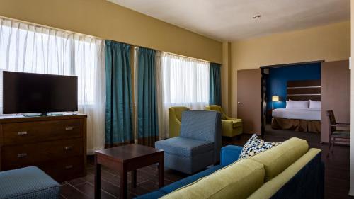 a hotel room with a couch and a tv and a bed at Holiday Inn Houston Downtown by IHG in Houston