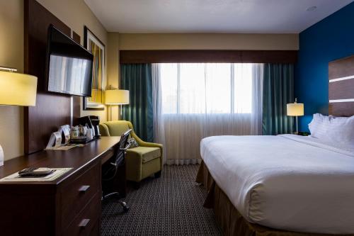 a hotel room with a bed and a desk at Holiday Inn Houston Downtown by IHG in Houston