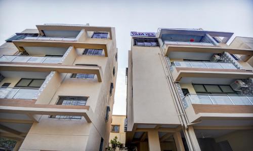 dos edificios de apartamentos altos con sus ventanas en Treebo Trend Yash Inn Kharadi, en Pune