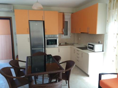 Sotirítsa的住宿－Dimitrios Apartments，厨房配有桌椅和冰箱。