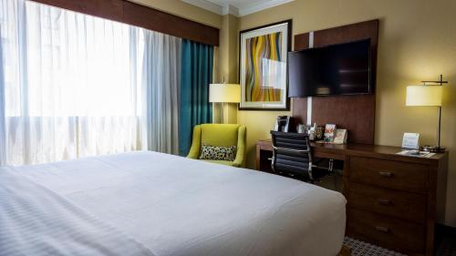 a hotel room with a bed and a desk and a television at Holiday Inn Houston Downtown by IHG in Houston