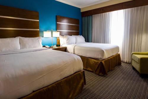 a hotel room with two beds and a chair at Holiday Inn Houston Downtown by IHG in Houston