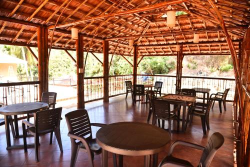 ein Restaurant mit Tischen und Stühlen in einem Pavillon in der Unterkunft Chembra Adobe in Kalpatta
