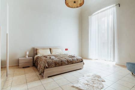 um quarto com uma cama e uma grande janela em Flores Home em Bari