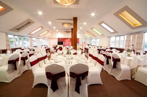 a banquet hall with white tables and white chairs at Rum Vang Hotel Da Lat in Da Lat