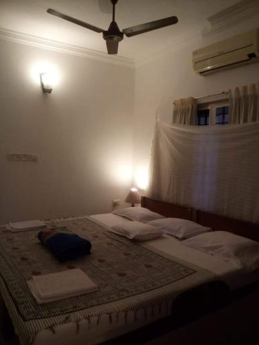 a bedroom with a large bed with a ceiling fan at Nathans Holiday Home in Cochin