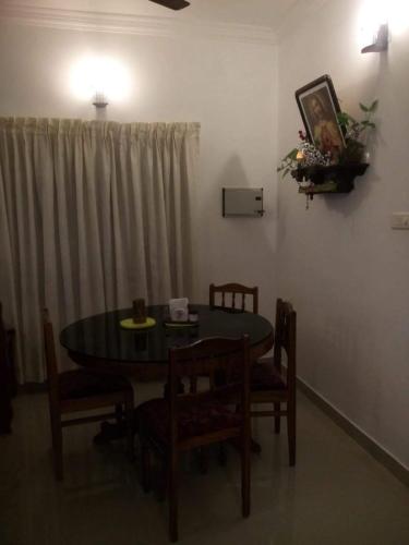 a dining room with a table and chairs and a window at Nathans Holiday Home in Cochin