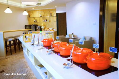 a counter with orange buckets on it in a kitchen at Menara Peninsula Hotel in Jakarta