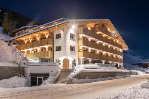 a large building in the snow at night at Brunnenhof Luxury Apartments in Lech am Arlberg