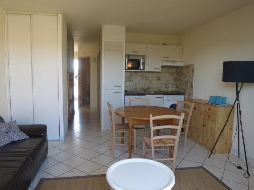 un salon avec une table et une cuisine dans l'établissement Appartement récent proche de la plage, à Biscarrosse-Plage