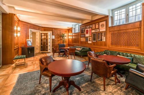 a living room with wooden walls and tables and chairs at Hotel Capital in Zagreb