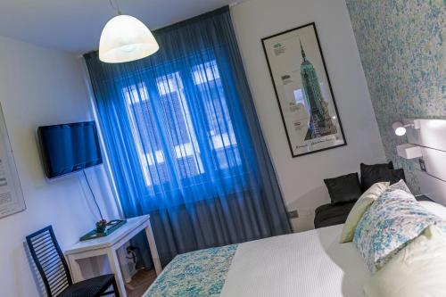 a bedroom with a bed and a window with a television at MURAT OTTO in Trieste