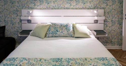 a bedroom with a large white bed with a headboard at MURAT OTTO in Trieste