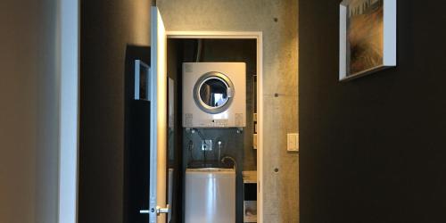 a room with a washing machine in a room at SOU東恩納 in Uruma