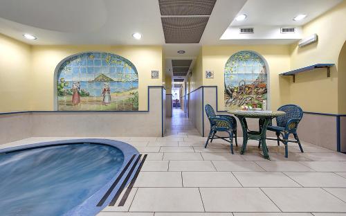a restaurant with a hot tub and a table and chairs at Hotel Royal Terme in Ischia