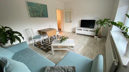 a living room with a blue couch and a television at Alte Brennerei in Uckerland