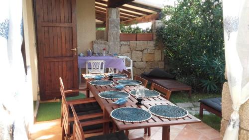 een houten tafel met borden op een patio bij Villetta Reparata in Santa Teresa Gallura