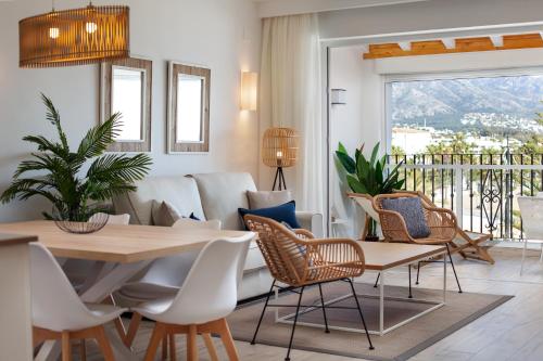 un soggiorno con tavolo, sedie e divano di Frontline Beach & Sea Views - 2 Bedrooms - 2 Bathrooms - Puerto Banús Apartment a Marbella
