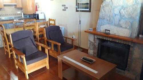 sala de estar con sillas y chimenea en CASA RURAL GREDOS, en San Martín de la Vega del Alberche