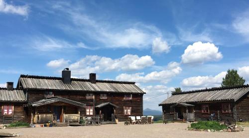 un vecchio fienile in legno con sedie di fronte di Knappgården a Särna