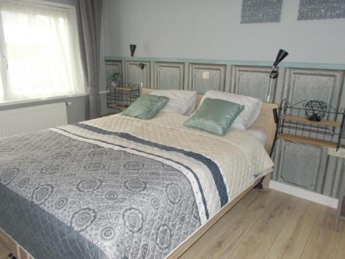sypialnia z dużym łóżkiem z 2 zielonymi poduszkami w obiekcie Middenpaed w mieście Balk