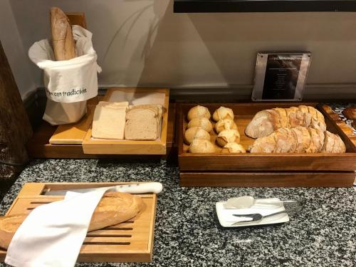 a table with two trays of bread and other pastries at Parador de Ribadeo in Ribadeo