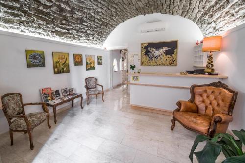 a living room with chairs and paintings on the walls at Bosa Queen House in Bosa