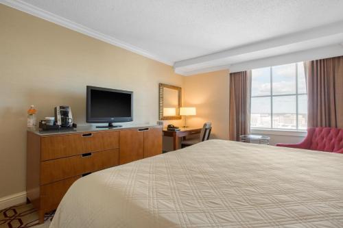 a hotel room with a bed, television and a desk at Omni Providence in Providence
