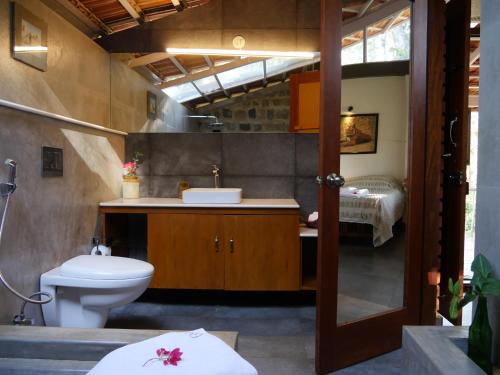 a bathroom with a toilet and a sink at Estate Stay - Riverside Coffee in Siddapur