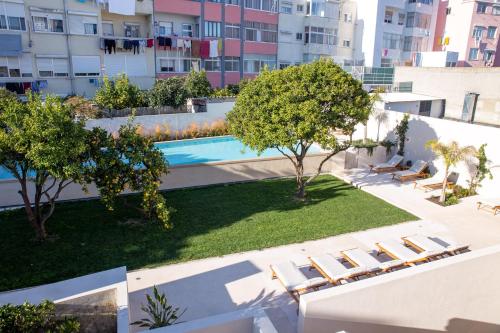 an overhead view of a swimming pool with chairs and trees at Casa René - Charming apartments in Almada